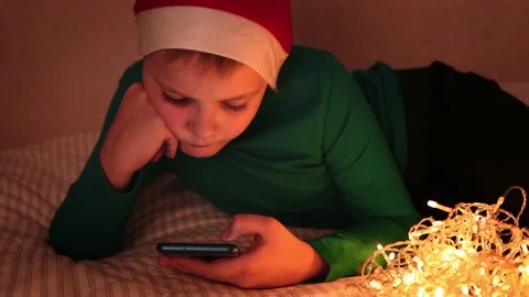 A boy lies on a bed with bright festive decorations Stock Footage 165395596