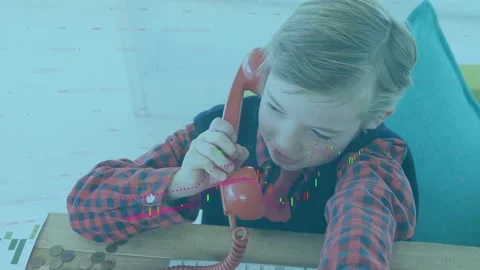 Boy lifting red handset, making pretend call while reaching keys and coins, tech Stock Footage 333413945