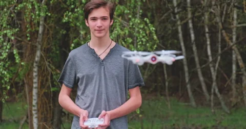 Boy lifts the drone using the remote control. Teenager launches a drone in th Stock Footage 135916647