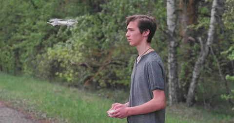 Boy lifts the drone using the remote control. Teenager launches a drone in th Stock Footage 152905331