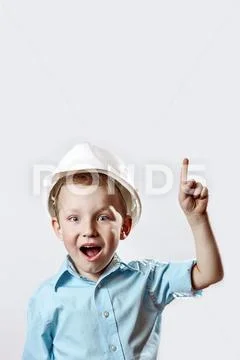Boy in the light blue shirt and construction helmet of the foreman raised a f Stock Photos