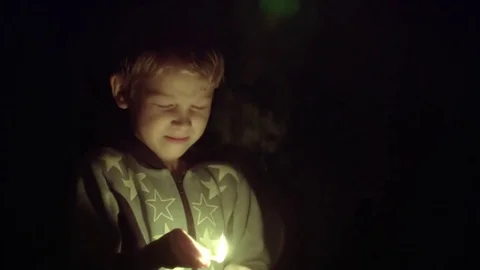 Boy light matches in the dark Stock Footage 76837029