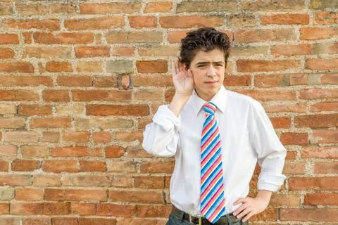 Boy listening in front of a wall Stock Photos