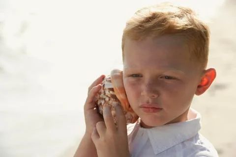 Boy listening to seashell Stock Photos