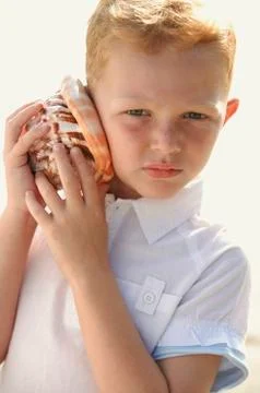 Boy listening to seashell Stock Photos