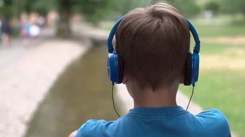 The boy listens to music on headphones Stock Footage