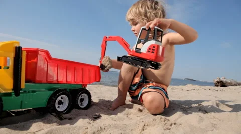 Boy loads sand with the help of excavator in the truck Stock Footage 55632539