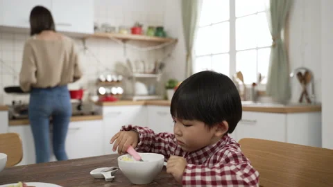 Boy with a look of hate as he picks up vegetable 스톡 동영상 172218988