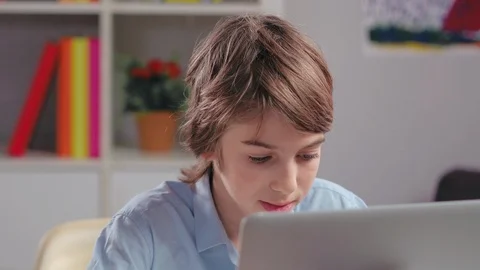 Boy looking attentively at laptop screen Video stock 98713347