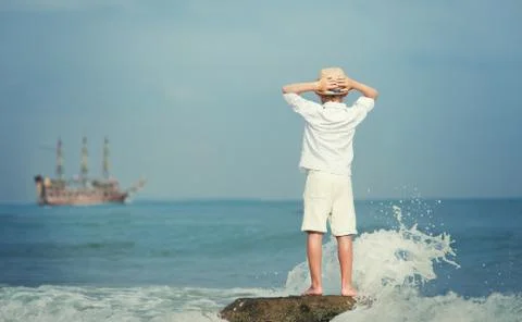 Boy looking on big old ship on the sea Foto stock