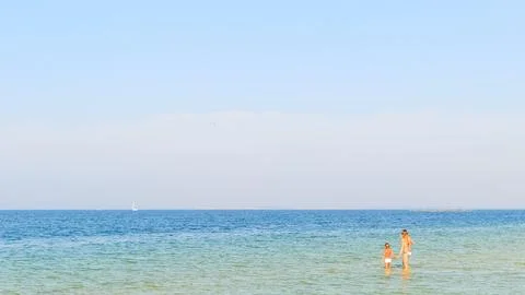 Boy looking on big old ship on the sea. Stock Photos