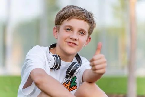 Boy looking at camera and smiling while showing thumb up. Foto stock