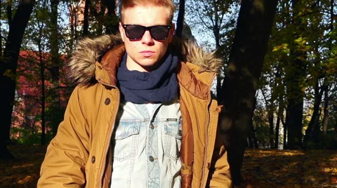 Boy looking to the camera in the autumnal park, steadycam shot, slow motion shot 스톡 동영상 57759243