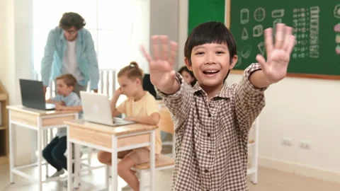 Boy looking at camera while waving hands and standing at blackboard. Pedagogy. Stock Footage 270401901