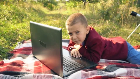 The boy is looking at the computer Stock Footage 96187971