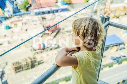 The boy is looking at the construction site. Chooses his future profession Stock Photos