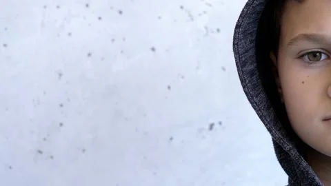 Boy looking directly to camera. Half face. Child near grunge gray wall Stock-Footage 132159262