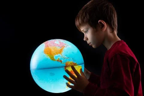 Boy looking at earth globe close up Stock Photos