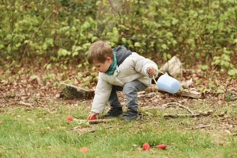 A boy looking for eggs in a bag for Easter 스톡 사진