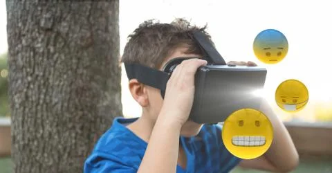 Boy looking at emojis through VR glasses Stock Photos