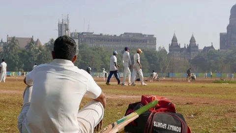 A boy looking at game of cricket in the Azad Ground opposite V.T. station. Vídeos de archivo 74180604