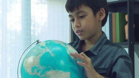 Boy looking at globe and finding for a country on map Stock Footage 105631739