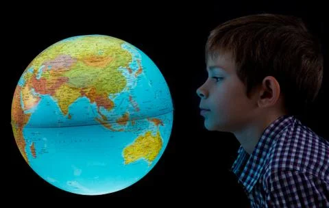 Boy looking at glowing earth globe Stock Photos