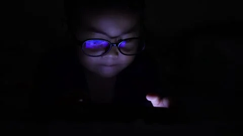 The boy is looking at his cell phone screen at night. Stock-Footage 333888219