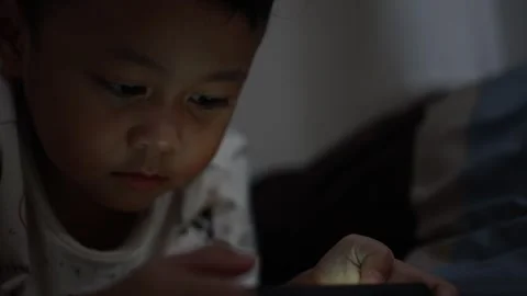 The boy is looking at his cell phone screen at night. Stock-Footage 333888248