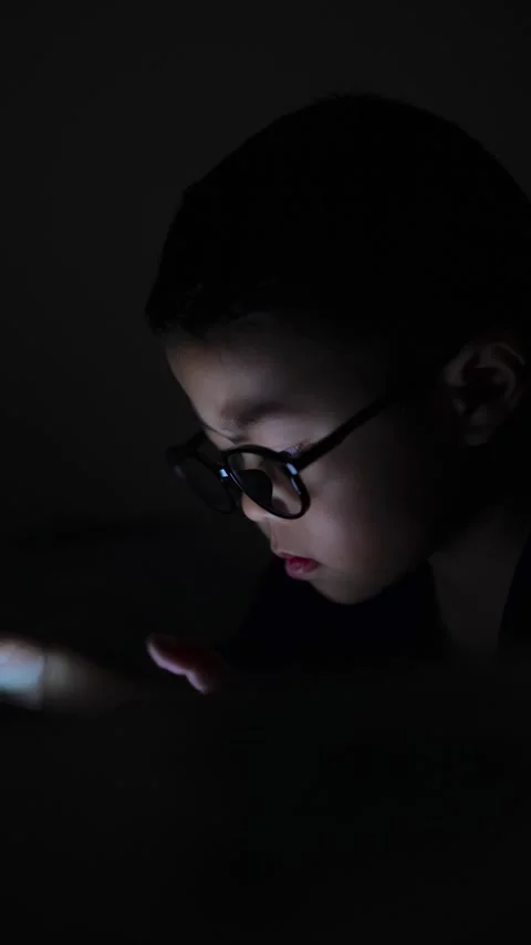 The boy is looking at his cell phone screen at night. Stock-Footage 333888250