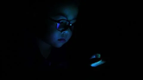 The boy is looking at his cell phone screen at night. Stock-Footage 333888255