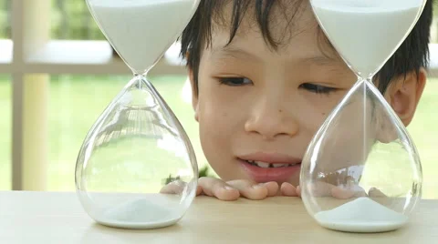 Boy looking at hourglass Stock Footage 57288417