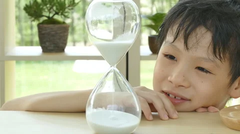 Boy looking at hourglass Stock Footage 57291049