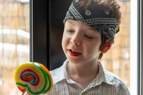 Boy looking at a lollipop Stock Photos
