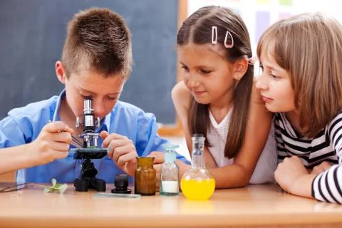 Boy looking into microscope Stock Photos