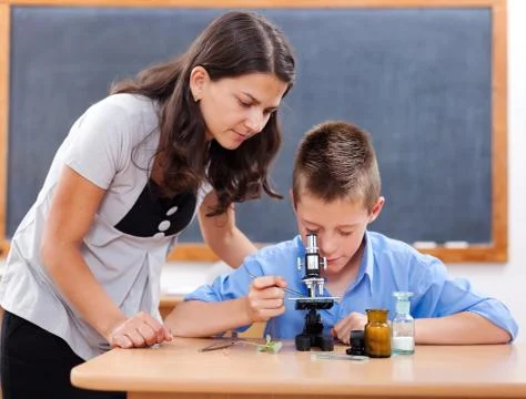 Boy looking into microscope Stock Photos