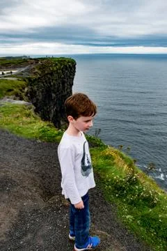 Boy looking out up the Cliffs of Moher Tourist Attraction in Ireland Stock Photos