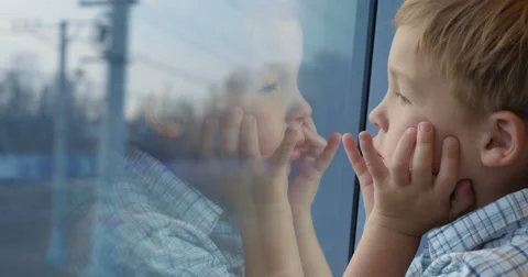 Boy looking out the train window with hands on the face Stock Footage 52374294