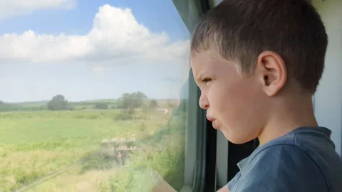 Boy looking out window. Blonde hair child riding on train. Stock Footage 255635029