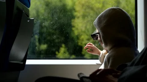 Boy looking out the window sitting on a train Stock Footage 313815733