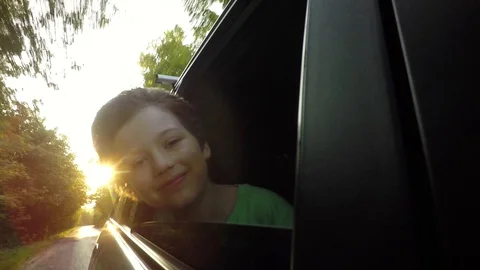 Boy looking out window while driving in car 스톡 동영상 94735663