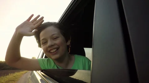 Boy looking out window while driving in car 스톡 동영상 94735676