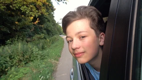 Boy looking out window while driving in car Video stock 111410138