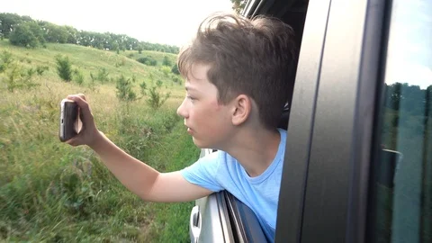 Boy looking out window while driving in car Video stock 111410408