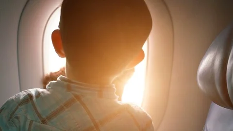 Boy looking outside of airplane window Stock Footage 76925426