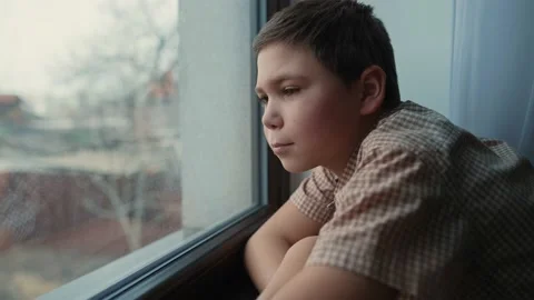 Boy looking outside the window Stock Footage 237628962