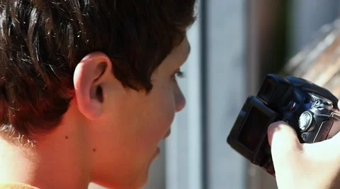 A boy looking at photos on a camera Stock Footage 62896659