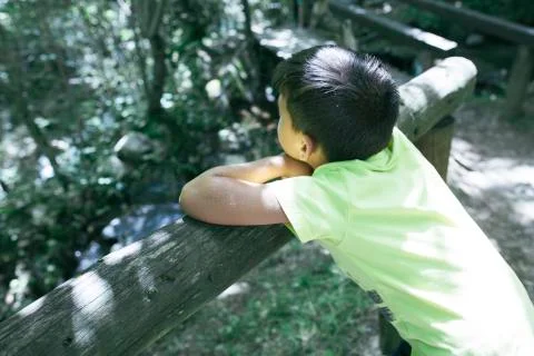 Boy looking at the river from a bridge Stock Photos