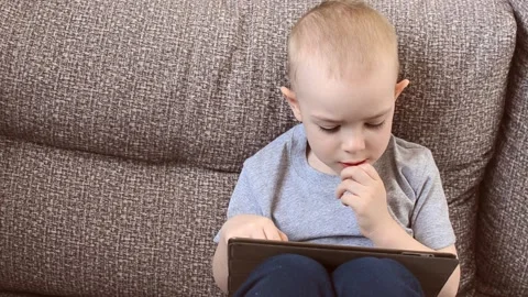 The boy is looking for something on the tablet Stock Footage 172538146