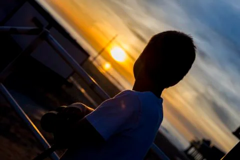 Boy looking at sunset Stock Photos